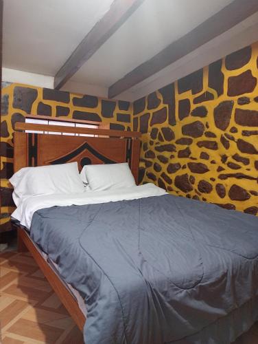 a bed in a room with a wall with at Sacred Point in Ollantaytambo