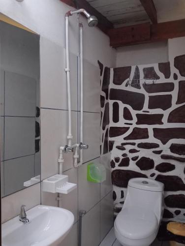 a bathroom with a toilet and a sink and a giraffe mural at Sacred Point in Ollantaytambo
