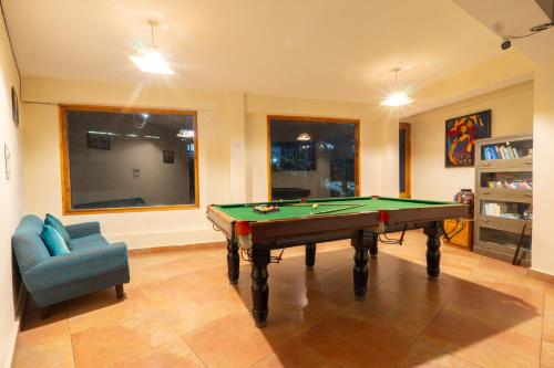 a living room with a pool table and a chair at Hotel Rising Star in Manāli