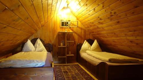 ザンクト・ゲオルゲン・オプ・ムーラウにあるHüttenferien Köberlhofの木造キャビン内のベッド2台が備わる部屋