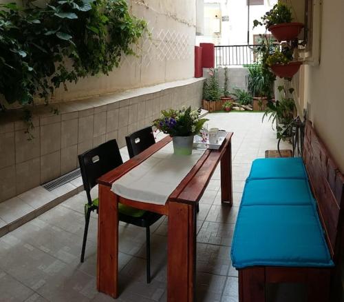een houten tafel met 2 stoelen en een tafel met bloemen bij Irida Equanimity and Cozy Apartment in Thessaloniki