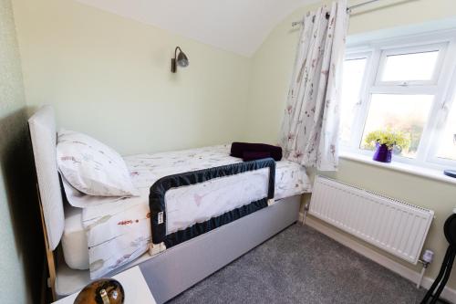 a small bedroom with a bunk bed with a window at One Bridge End in Pevensey