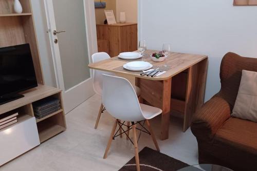 een kleine eettafel met 2 stoelen en een televisie bij Irida Equanimity and Cozy Apartment in Thessaloniki