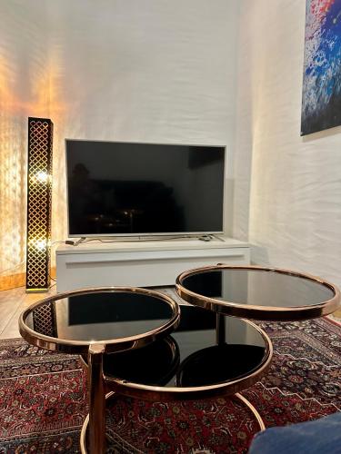 a living room with two tables and a flat screen tv at Domizil in Schleiden