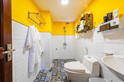 La salle de bains est pourvue de toilettes blanches et d'un lavabo. dans l'établissement Ngáo Home, à Hanoï