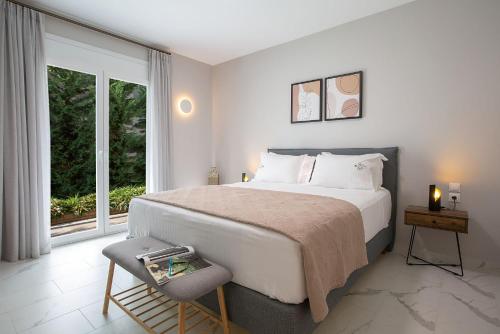 a bedroom with a large bed and a window at Grappolo Lefkada Villas - Villa Vertzami just 2 km from Lefkada town in Apolpaina