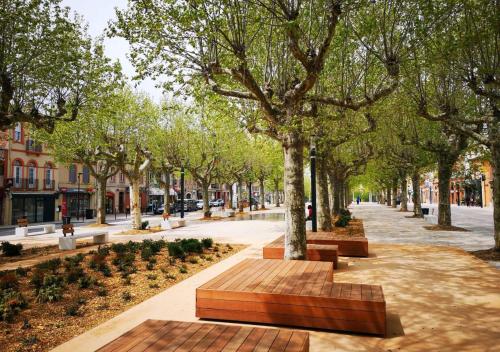 un parc avec des bancs et des arbres dans une rue dans l'établissement RESIDENCE LES JOYAUX, à Muret