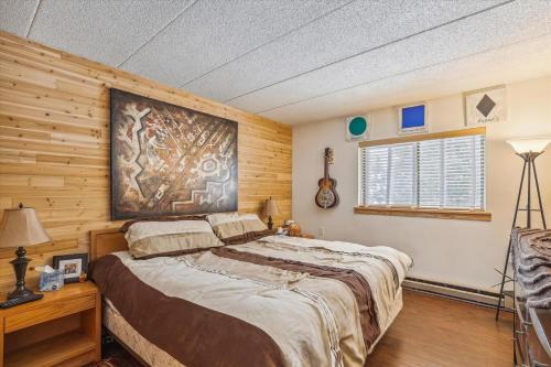 a bedroom with a large bed and wooden walls at Pinnacle B14 in Killington