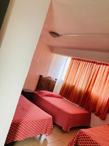 a room with two beds and a window at La Sirenita in Veracruz