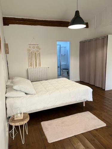 a bedroom with a large white bed and a table at Domaine Saladry in Villepinte