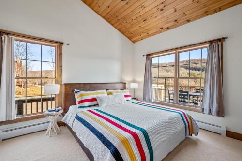 een slaapkamer met een bed en 2 ramen bij New & Stunning Chalet! Reno'd, Hot-Tub, Barrel Sauna, Slope Views, Fire Pit in Ellicottville