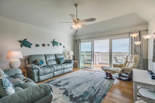 a living room with a couch and a table at Marsh Views - Nautical Watch - Steps to the Pool in Harbor Island
