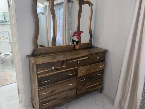 a wooden dresser with a mirror on top of it at MBS Travel Holistic Guest House in Mammee Bay