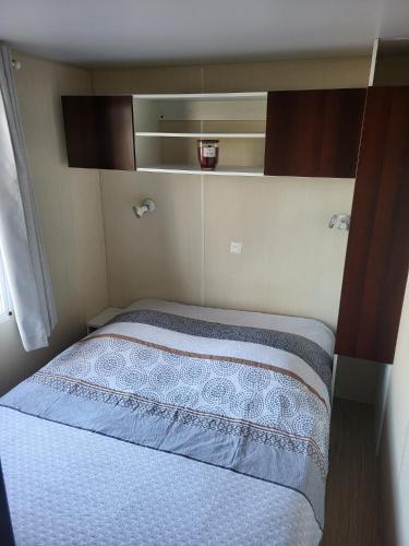 une petite chambre avec un lit dans une petite pièce dans l'établissement mobil home v198, à Sigean