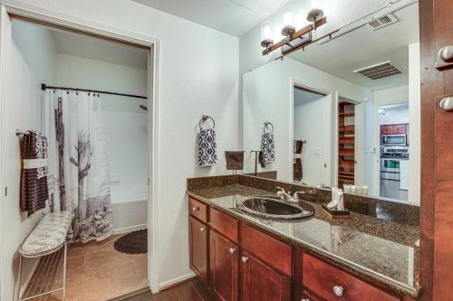 a bathroom with a sink and a large mirror at Scottsdale Condo with Fireplace and Community Pools! in Scottsdale