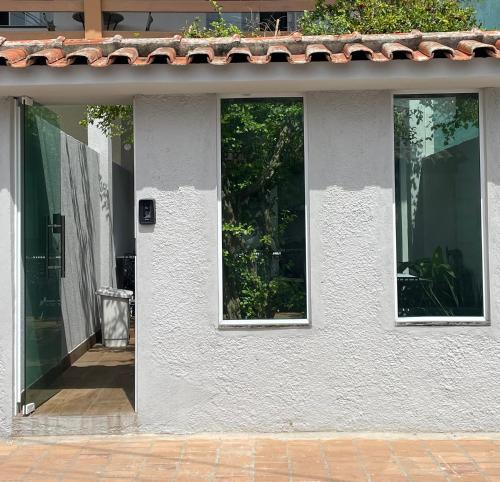 un edificio blanco con tres ventanas. en Brisa dos Anjos Suítes en Arraial do Cabo