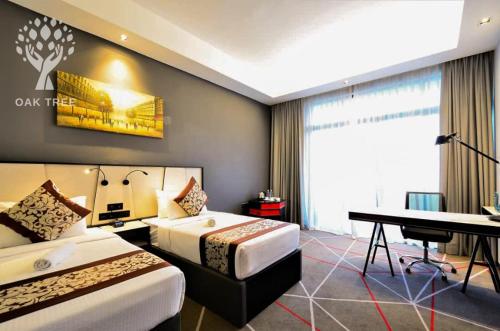 a hotel room with two beds and a desk at Red M101 by Oak Tree in Kuala Lumpur