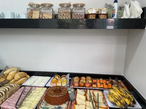 a shelf with many different types of food on it at Brisa dos Anjos Suítes in Arraial do Cabo