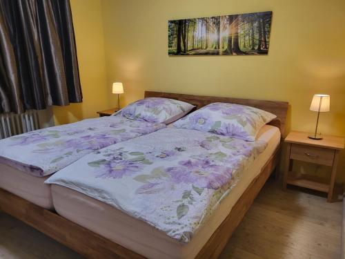 a bedroom with a bed with a purple comforter at Panoramablick Winterberg - 3 Zimmer in Winterberg