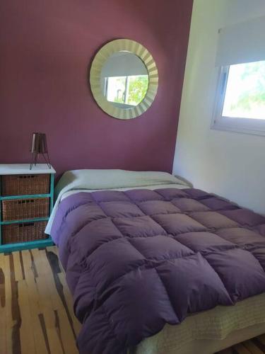 a purple bed in a bedroom with a mirror at depto muy cómodo en 1er piso in La Plata