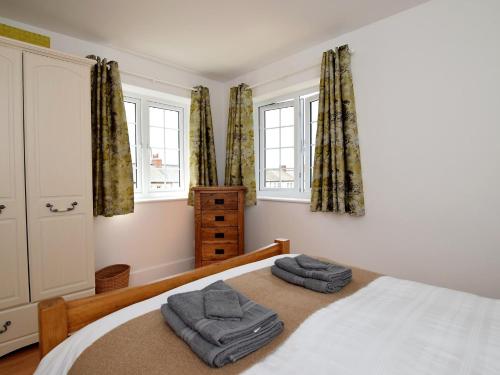 a bedroom with a bed with two towels on it at 3 Bed in Folkestone 75607 in Sandgate