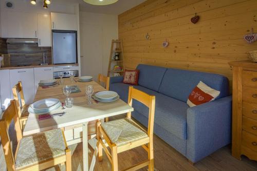 un salon avec une table et un canapé bleu dans l'établissement Studio Pastilla - Welkeys, à Huez