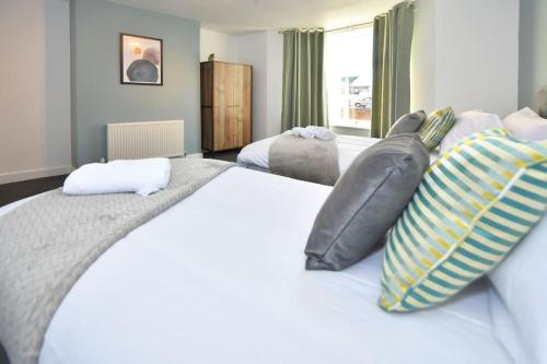 a bedroom with a large white bed with pillows at Lyndale House - By Sigma Stays in Crewe