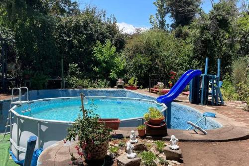 una piscina con un tobogán en un patio trasero en Acogedora cabaña entre montañas en San Alfonso