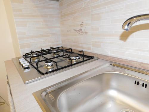 uma placa de fogão numa cozinha com um lavatório em Cariteo Home em Nápoles