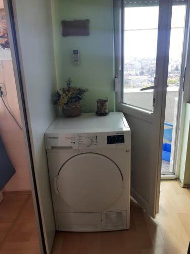eine Waschmaschine und einen Trockner in einem Zimmer mit Fenster in der Unterkunft Apartman Kumanovo Centar strog in Kumanovo