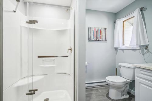 a white bathroom with a shower and a toilet at Hemlock Ridge 6A in Killington