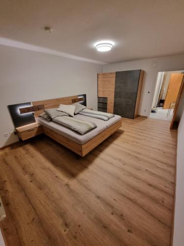 1 dormitorio con 1 cama grande y suelo de madera en Gerlitzen, Kanzelhöhe, Über den Wolken, Haus Enzian, en Deutschberg