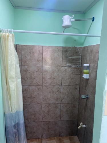 a bathroom with a shower with a glass door at HOSTEL CASA MARINA in Puerto Limón