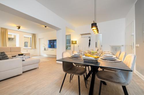 a dining room and living room with a table and chairs at Primero City-Loftdomizil Innenstadt 84qm Netflix in Augsburg