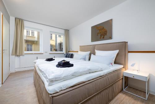 um quarto com uma cama grande e lençóis brancos em Primero City-Loftdomizil Innenstadt 84qm Netflix em Augsburg