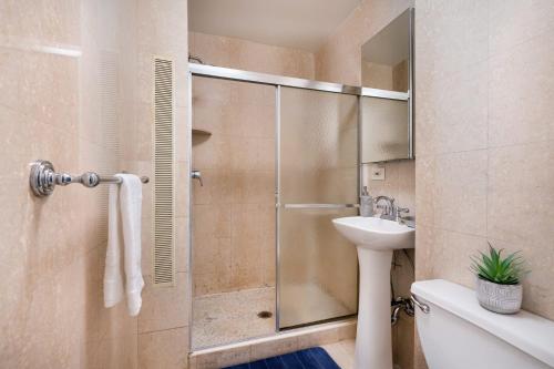 La salle de bains est pourvue d'une douche et d'un lavabo. dans l'établissement 73-1004 New Studio UWS Doorman Gym, à New York