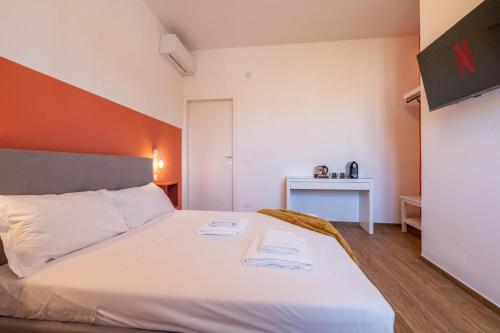 een slaapkamer met een wit bed en een oranje muur bij Toli's guest in Pisa