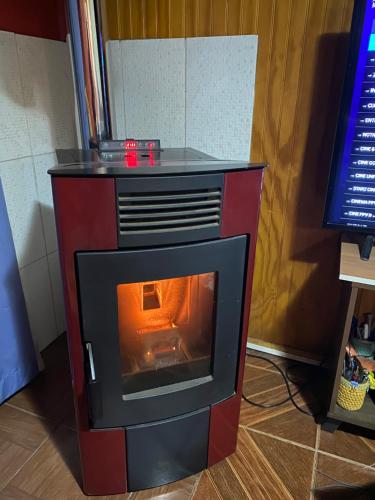 um fogão vermelho e preto num quarto em Habitación privada Coyhaique em Coihaique