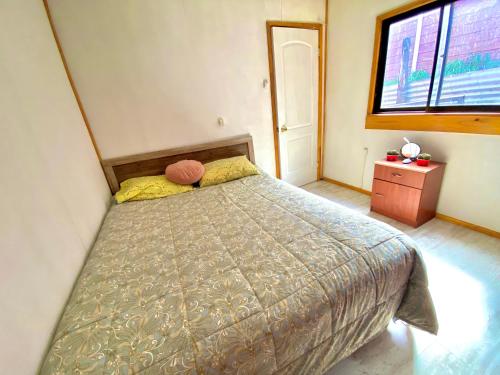 um quarto com uma cama e uma janela em Habitación privada Coyhaique em Coihaique