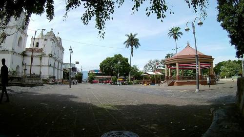 eine Stadtstraße mit einem Gebäude und einem Pavillon in der Unterkunft Hotel América Heredia in Heredia