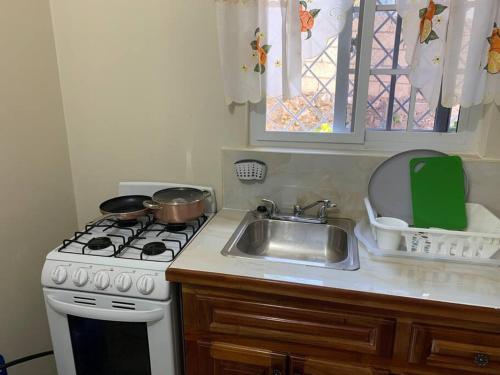 a kitchen with a sink and a stove and a counter top at Beach Walk Studio near Mobay Hip Strip in Montego Bay