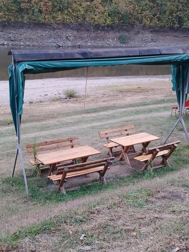 a picnic table and benches under a canopy at Krčma u Planini in Bojnik