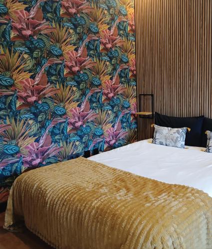 1 dormitorio con 1 cama y papel pintado con motivos florales en Fridda House Oviedo Hospital, en Oviedo