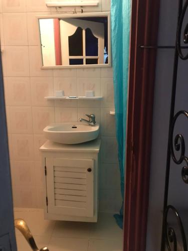 a bathroom with a sink and a mirror at Hôtel Riad Gnaoua in Essaouira