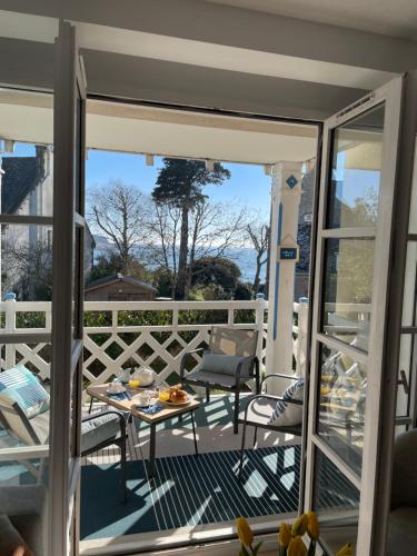 a patio with a table and chairs on a balcony at L'ECHAPPÉE BELLE avec piscine in Bénodet
