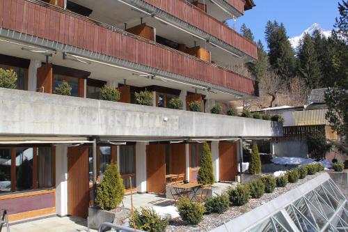 a building with a courtyard with plants in front of it at LODGE - Elements Lodge in Grindelwald
