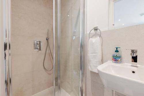 uma casa de banho com um chuveiro e um lavatório. em Brand New 2-Bed Hs Harry Potter Wat Hosp Sleeps 6 em Watford