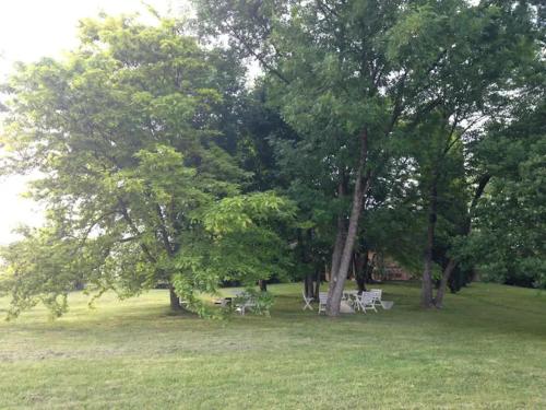メデザーノにあるVilla Mimosaの木々の茂る公園内のテーブルと椅子