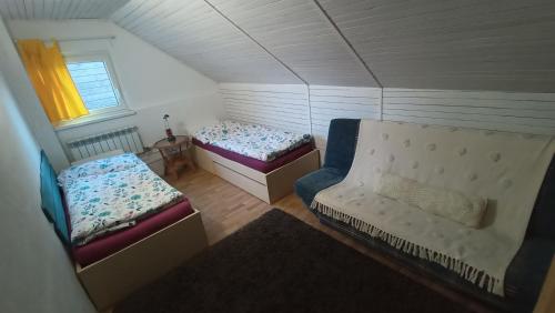 een kleine kamer met 2 bedden en een bank bij TUTTO House in Frýdlant nad Ostravicí