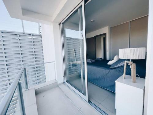a room with a balcony with a bed and a window at Moderno dúplex a estrenar in Godoy Cruz